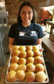 Dalia brings out freshly baked yeast rolls for the bakery.